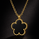 black and gold clover medallion necklace on a black background
