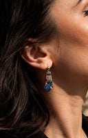 Mohave multi copper turquoise drop earrings in a black velvet jewelry box, highlighting the rich jewel-toned composite stone in gold bezel setting.