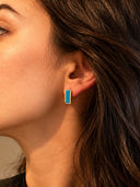 urquoise bar stud earrings with 18K gold plated brass frame displayed in a black velvet jewelry box. The earrings feature a smooth rectangular natural turquoise gemstone set between two polished gold rails.