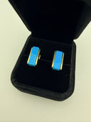 urquoise bar stud earrings with 18K gold plated brass frame displayed in a black velvet jewelry box. The earrings feature a smooth rectangular natural turquoise gemstone set between two polished gold rails.
