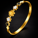 gold bangle bracelet with white and black clover symbols