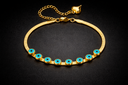 gold bracelet with flat chain blue evil eye symbols and heart charm