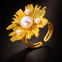 Onyx adjustable Bloom ring in gold with sculptural floral design and pearl accents on dark background