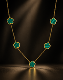 Gold clover necklace with green stone motifs on delicate chain, luxury statement jewellery