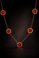 Necklace with red clover pendants on a dark background