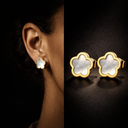 clover shaped black and white earrings displayed on dark background