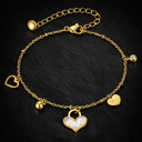 Onyx Love Charm Bracelet in gold with delicate chain and multiple heart charms on dark background